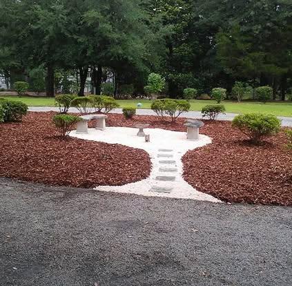 Custom landscape design with mulch, stepping stones, and benches