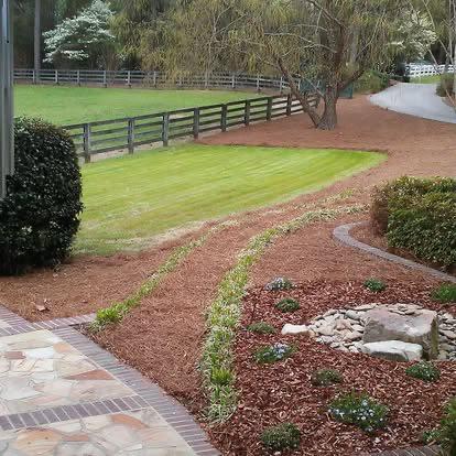 Professional landscaping with mulch beds and stone edging